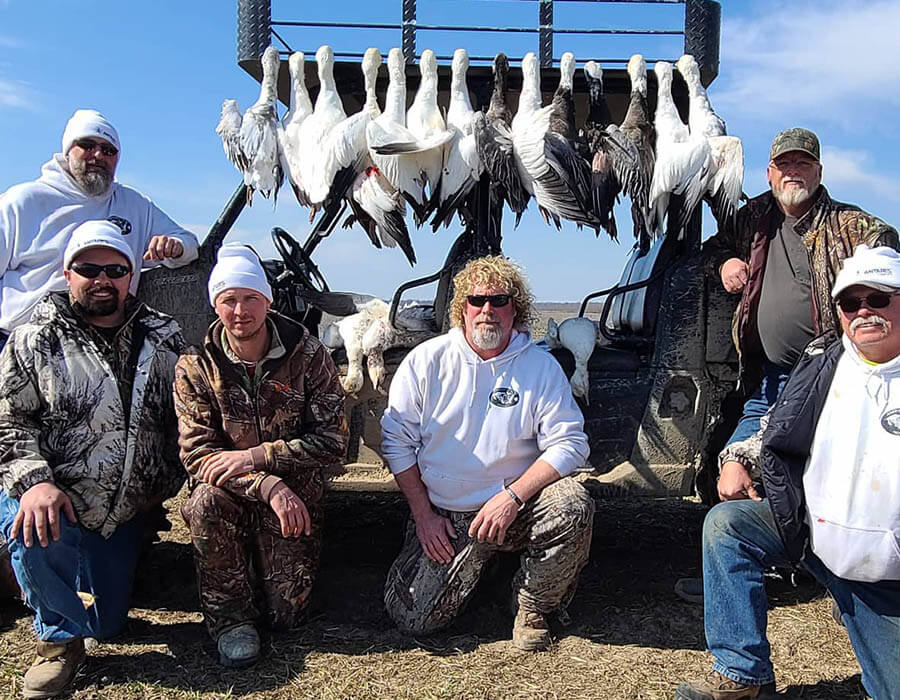 goose hunters posing in front of geese