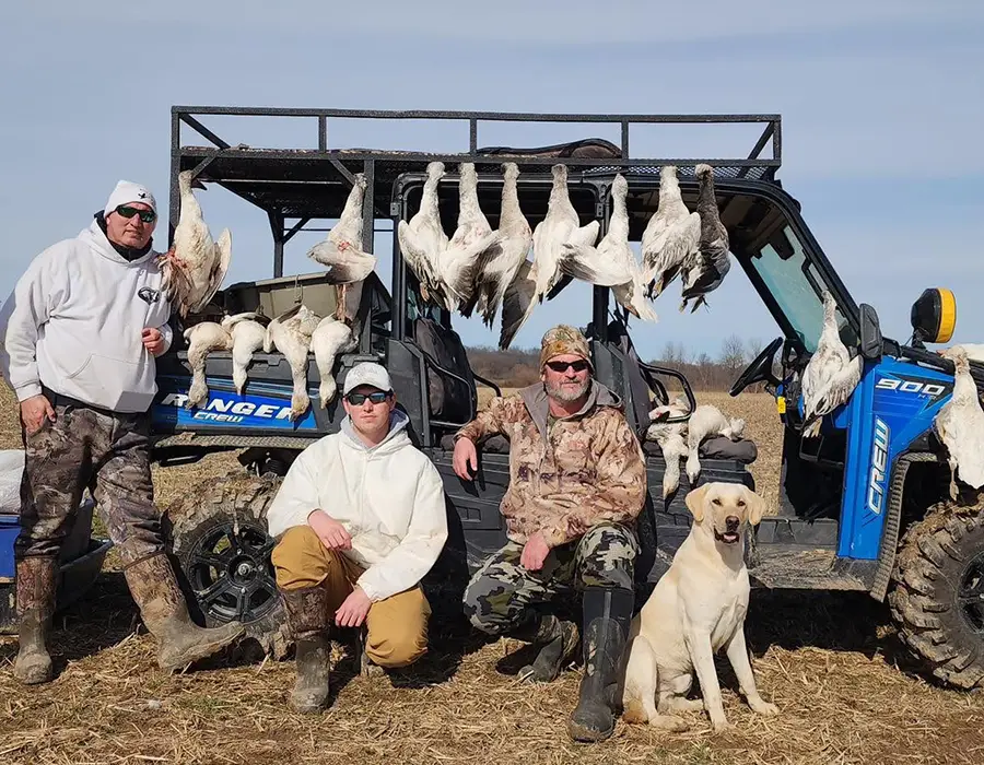 goose hunters posing in front of geese